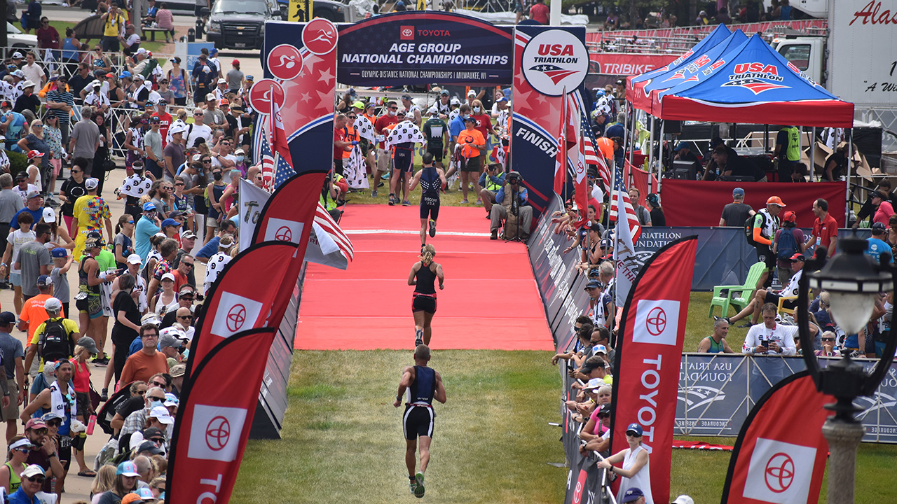 Athletes spring toward the finish line during the 2021 USA Triathlon Age Group National Championships in Milwaukee.