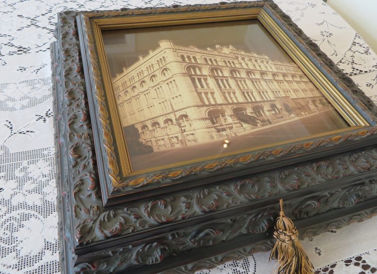 When he retired from National Business Furniture, George Mosher received this frame full of mounted photos of his career from employees. He displays it proudly here on his dining room table.