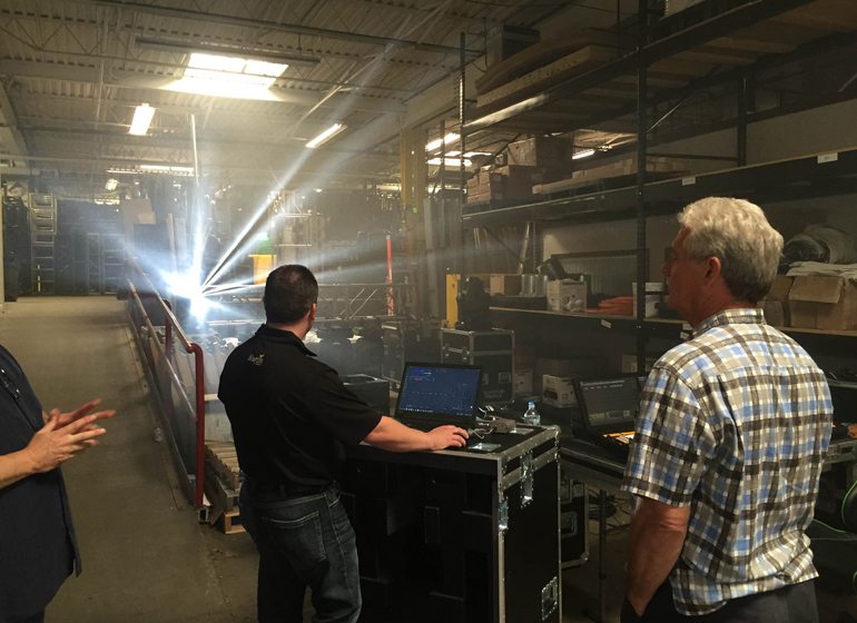 Clearwing Productions president and CEO Gregg Brunclik checks out the capabilities of a new light system and stands before rows of stage equipment at Clearwing’s West Allis warehouse.