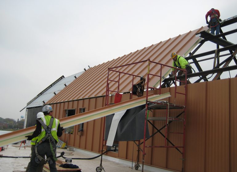 Workers install a Crafts, Inc. metal roof.