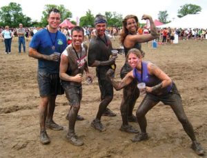 Dan Sisel (left) and Jayme Sisel (top right) pose with friends after participating in a mud run.