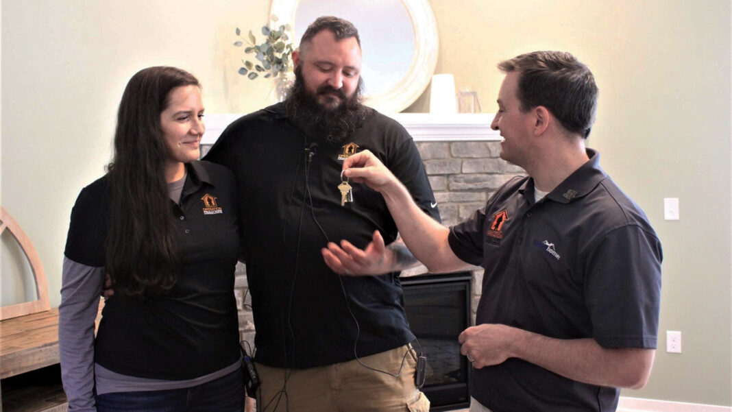 Jessica and Tyson Cole are handed the keys to their new Menomonee Falls home from David Belman, president of Waukesha-based Belman Homes.